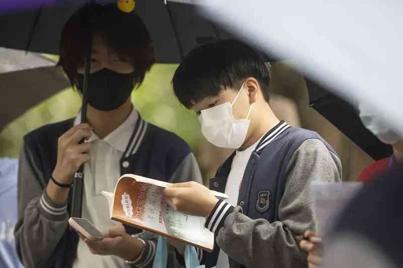 昨天，閔行區上海實驗學校西校考點，考生在雨中撐傘候考.jpeg