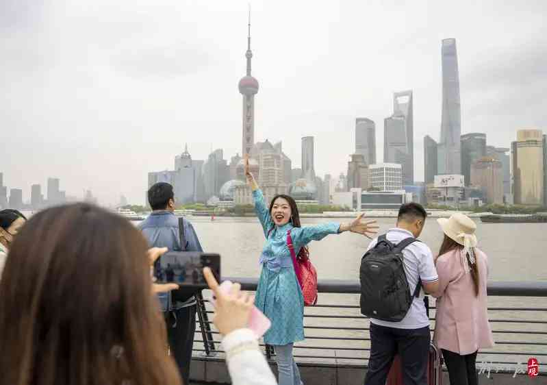 從內蒙古來上海遊玩的李女士在外灘觀景平臺張開雙臂與對岸的陸家嘴標誌性建築合影.jpeg